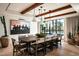 Elegant dining room with a large wood table, statement art, and views of the refreshing pool outside at 5050 N Camelback Ridge Dr # 2306, Scottsdale, AZ 85251