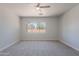 A bedroom with a neutral color scheme features a ceiling fan and a large window at 5434 W T Ryan Ln, Laveen, AZ 85339