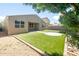 Spacious backyard featuring manicured lawn, mature tree, a covered patio, and desert landscaping at 626 W Tallula Trl, San Tan Valley, AZ 85140