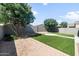 Expansive backyard featuring artificial turf, desert landscaping, mature trees, and a shaded gazebo at 626 W Tallula Trl, San Tan Valley, AZ 85140