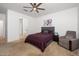 Spacious bedroom with carpet, ceiling fan, and connecting bathroom for added convenience and privacy at 626 W Tallula Trl, San Tan Valley, AZ 85140
