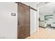 Hallway with sliding barn door leads to a cozy living area, enhancing privacy and style at 626 W Tallula Trl, San Tan Valley, AZ 85140
