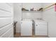 Bright laundry room with modern white appliances, storage shelf, and neutral tile flooring at 626 W Tallula Trl, San Tan Valley, AZ 85140