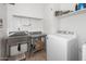 Functional laundry room features stainless steel sink, workspace, and white appliances for added convenience at 626 W Tallula Trl, San Tan Valley, AZ 85140