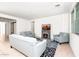 Bright living room with tile flooring, featuring a fireplace, stylish sofas, and an open layout to the kitchen at 626 W Tallula Trl, San Tan Valley, AZ 85140