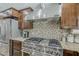 Gourmet kitchen featuring a stainless steel range, range hood, tile backsplash, and custom cabinetry at 6302 E Turquoise Ave, Paradise Valley, AZ 85253