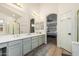 Bathroom with dual sinks, a bathtub, and a view of the main bedroom with a four-poster bed frame at 6846 S 26Th Pl, Phoenix, AZ 85042