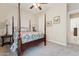 Bedroom with four poster bed, neutral walls, ceiling fan, and soft carpet at 7511 S Parkcrest St, Gilbert, AZ 85298