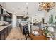 Open-concept kitchen with island, dark cabinets, stainless appliances, and view to living area at 7511 S Parkcrest St, Gilbert, AZ 85298