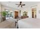 Bright main bedroom with ceiling fan, carpet floors and access to covered patio at 7511 S Parkcrest St, Gilbert, AZ 85298
