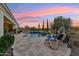 Beautiful backyard with a sparkling pool, comfortable lounge chairs, and lush green landscaping at 7511 S Parkcrest St, Gilbert, AZ 85298