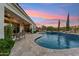 Luxurious pool area with travertine decking, a charming rubber ducky, and lush landscaping at 7511 S Parkcrest St, Gilbert, AZ 85298