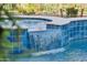 Close up of the waterfall feature flowing into the sparkling blue pool at 7511 S Parkcrest St, Gilbert, AZ 85298