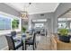 Bright dining room featuring a modern chandelier, glass table and views into the living room at 7710 E Gainey Ranch Rd # 206, Scottsdale, AZ 85258