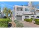 Modern townhouse showcasing a three-car garage and landscaped front yard on a sunny day at 7710 E Gainey Ranch Rd # 206, Scottsdale, AZ 85258