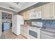 This bright kitchen boasts white appliances, ample storage, and convenient access to laundry at 7710 E Gainey Ranch Rd # 206, Scottsdale, AZ 85258