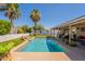 Inviting backyard pool surrounded by lush landscaping, palm trees, and a covered patio area at 823 N 81St St, Mesa, AZ 85207