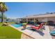 Backyard view featuring a sparkling pool, patio with seating, and vibrant artificial grass at 823 N 81St St, Mesa, AZ 85207