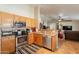 Well-lit kitchen featuring stainless steel appliances and wooden cabinets open to the living room at 823 N 81St St, Mesa, AZ 85207