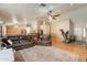 Bright and open living room featuring a large leather couch, ceiling fan, and views into the kitchen at 823 N 81St St, Mesa, AZ 85207