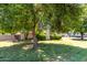 A large backyard with mature tree coverage, complemented by a brick fence and green lawn at 840 E 2Nd St, Mesa, AZ 85203