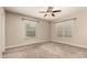 Cozy bedroom with plush carpeting, ceiling fan, and ample natural light through large windows at 840 E 2Nd St, Mesa, AZ 85203
