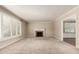 Bright living room featuring a fireplace, plush carpeting, and plantation shutters for abundant natural light at 840 E 2Nd St, Mesa, AZ 85203