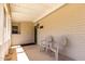 Covered porch featuring an entry door, storage cabinets and two chairs creating a cozy entrance space at 840 E 2Nd St, Mesa, AZ 85203