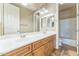 Bathroom featuring double sinks, a large mirror, wood cabinets, and a shower-tub combo at 8503 W Coyote Dr, Peoria, AZ 85383