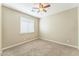 Carpeted bedroom offers a ceiling fan, neutral walls, and window with blinds at 8503 W Coyote Dr, Peoria, AZ 85383