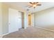 Carpeted bedroom features a ceiling fan and closet at 8503 W Coyote Dr, Peoria, AZ 85383