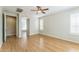 Spacious bedroom boasts hardwood floors, neutral walls, ceiling fan, and view to the primary bathroom at 8503 W Coyote Dr, Peoria, AZ 85383