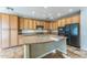 Well-lit kitchen featuring wooden cabinets, granite countertops, a central island, and modern black appliances at 8503 W Coyote Dr, Peoria, AZ 85383