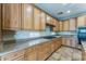 A functional kitchen showcases wood cabinets, granite countertops, tile floors, and modern appliances at 8503 W Coyote Dr, Peoria, AZ 85383