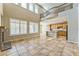 Open living room featuring a stone fireplace, oversized windows, and seamlessly flowing into an adjacent kitchen at 8503 W Coyote Dr, Peoria, AZ 85383
