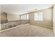 Spacious loft with neutral carpet, wood banister, and natural light from large windows create a comfortable living space at 8503 W Coyote Dr, Peoria, AZ 85383