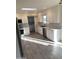 Bright kitchen with stainless steel appliances, white cabinets, tiled backsplash, and wood-look tile flooring at 10025 W Shasta W Dr, Sun City, AZ 85351