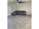 Bright living room featuring a ceiling fan, sectional sofa, and wood-look tile flooring at 10025 W Shasta W Dr, Sun City, AZ 85351