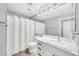 Bright bathroom featuring a large mirror, a single sink vanity, and a shower with a white curtain at 11375 E Sahuaro Dr # 1008, Scottsdale, AZ 85259