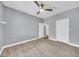 Spacious bedroom with wood-look tile floors, ceiling fan, and access to another room through white doors at 11375 E Sahuaro Dr # 1008, Scottsdale, AZ 85259