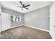 Bedroom featuring wood-look tile floors, a ceiling fan, a window view, and white doors at 11375 E Sahuaro Dr # 1008, Scottsdale, AZ 85259
