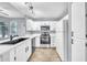 Updated kitchen features white cabinets, quartz countertops, stainless steel appliances and wood-look tile flooring at 11375 E Sahuaro Dr # 1008, Scottsdale, AZ 85259