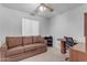 Cozy bedroom featuring a brown couch, ceiling fan, desk, and neutral tones at 12029 N 44Th Dr, Glendale, AZ 85304