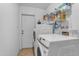 Laundry area with modern, white appliances and overhead shelving for storage at 12029 N 44Th Dr, Glendale, AZ 85304