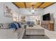 Open living room with a large sectional, vaulted ceilings, a ceiling fan, and a wooden tv stand at 12029 N 44Th Dr, Glendale, AZ 85304
