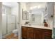 Well-lit bathroom with a shower, vanity, large mirror, and storage at 1407 W Chilton St, Chandler, AZ 85224