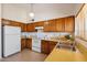 Kitchen with wood cabinets and white appliances at 1407 W Chilton St, Chandler, AZ 85224