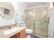 Bathroom featuring a framed glass shower, a rounded mirror, and a mounted cabinet at 14300 W Bell Rd # 6, Surprise, AZ 85374