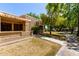 Charming front exterior view with a cozy, covered patio, lush trees, and walkway at 14300 W Bell Rd # 6, Surprise, AZ 85374