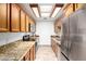 Well-lit kitchen featuring wooden cabinets, granite countertops, and stainless steel appliances at 14300 W Bell Rd # 6, Surprise, AZ 85374